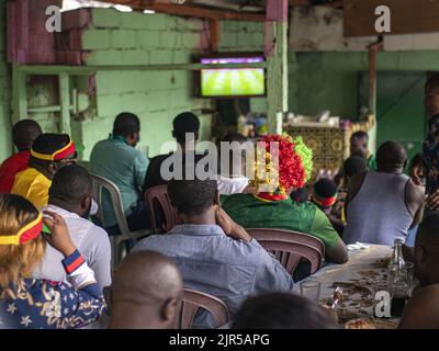 I fan del Camerun-Etiopia assistono alla partita Camerun-Etiopia per la Coppa delle Nazioni 2021 in Camerun, 14 gennaio 2022, in un ristorante camerone realizzato localmente in un quartiere di classe operaia di Libreville. Foto Stock