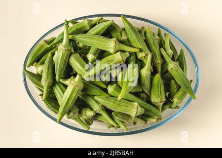 Okra crudo fresco in una ciotola di vetro. Concetto di alimentazione sana Foto Stock