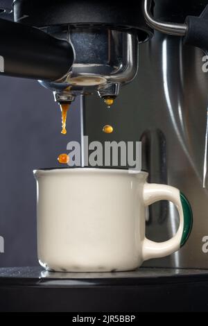 Macchina da caffè per preparare l'espresso in una tazza bianca. Foto Stock