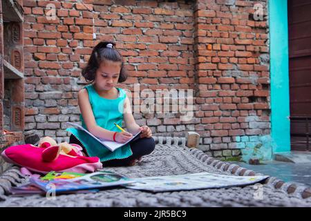 Ritratto del bambino che studia su una culla nel cortile Foto Stock