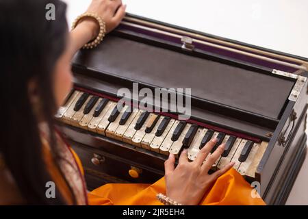 Vista ravvicinata della donna che suona l'armonio Foto Stock