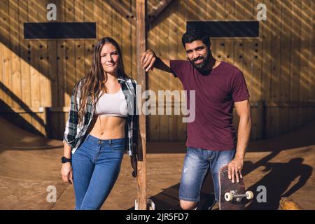 Immagine di diversi amici femminili e maschili con skateboard in skate Park Foto Stock