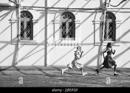 Fort Kochi, Kerala, India - 10 ottobre 2011: Due ragazze studentesche indiane che corrono lungo la Basilica di Santa Cruz dopo la lezione Foto Stock