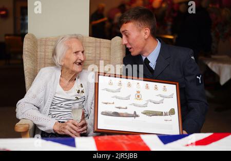 La veterana WAAF di 99 anni, Margaret 'Peggy' Terry, è presentata cinque shillings argentati in tempo di guerra e un'immagine incorniciata da William Anderson, specialista dell'aria di classe 1, alla Gwernllwyn Care Home, Gorslas, Galles, come un gesto di apprezzamento per il suo servizio quando, durante una recente conversazione, Ha scherzosamente menzionato a AS1 Anderson era ancora dovuta cinque scellini dopo aver lasciato la RAF, nel 1945. Data immagine: Lunedì 22 agosto 2022. Foto Stock