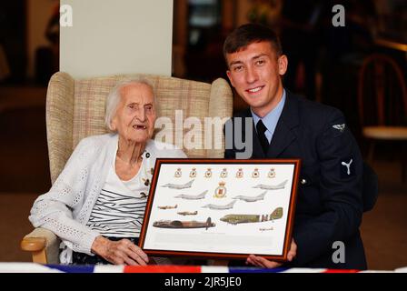 La veterana WAAF di 99 anni, Margaret 'Peggy' Terry, è presentata cinque shillings argentati in tempo di guerra e un'immagine incorniciata da William Anderson, specialista dell'aria di classe 1, alla Gwernllwyn Care Home, Gorslas, Galles, come un gesto di apprezzamento per il suo servizio quando, durante una recente conversazione, Ha scherzosamente menzionato a AS1 Anderson era ancora dovuta cinque scellini dopo aver lasciato la RAF, nel 1945. Data immagine: Lunedì 22 agosto 2022. Foto Stock