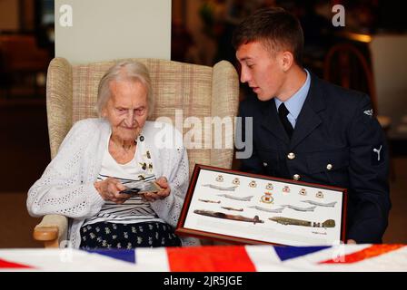 La veterana WAAF di 99 anni, Margaret 'Peggy' Terry, è presentata cinque shillings argentati in tempo di guerra e un'immagine incorniciata da William Anderson, specialista dell'aria di classe 1, alla Gwernllwyn Care Home, Gorslas, Galles, come un gesto di apprezzamento per il suo servizio quando, durante una recente conversazione, Ha scherzosamente menzionato a AS1 Anderson era ancora dovuta cinque scellini dopo aver lasciato la RAF, nel 1945. Data immagine: Lunedì 22 agosto 2022. Foto Stock