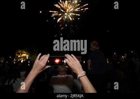 Parga Grecia, una folla di turisti che si divertono con uno spettacolo di fuochi d'artificio nel cielo notturno in occasione della celebrazione del 15 agosto 2022 nella città di parga in grecia, epiro Foto Stock