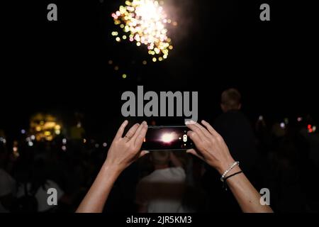 Parga Grecia, una folla di turisti che si divertono con uno spettacolo di fuochi d'artificio nel cielo notturno in occasione della celebrazione del 15 agosto 2022 nella città di parga in grecia, epiro Foto Stock