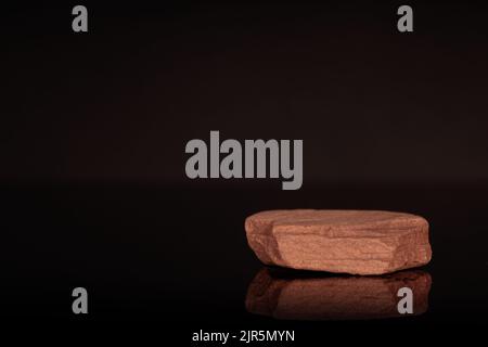 Mockup, podio in pietra per mostrare imballaggio e prodotto su sfondo nero scuro, spazio libero. Foto Stock