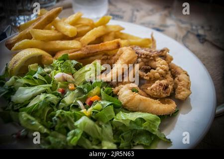 Un piatto di calamari fritti e insalata verde Foto Stock