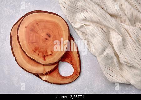 Taglieri e sottobicchieri su un tavolo grigio in cemento con un asciugamano da cucina. Modello per la visualizzazione degli alimenti. Vista dall'alto con spazio di copia Foto Stock