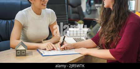 Contratto di vendita dell'agente domestico di prestito di bene immobile al contratto finanziario di assicurazione che firma e sta spiegando ai clienti alla proprietà dell'ufficio. manager Foto Stock