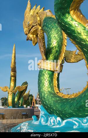 Grandi statue di nagas verdi e d'oro (serpenti mitici) sulla passeggiata lungo il fiume Mekong a Nong Khai, Thailandia Foto Stock