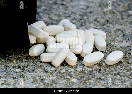 Farmaci scaduti, concetto di assistenza sanitaria. Farmaci da prescrizione su un background concreto. Foto Stock