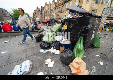 Edimburgo, Scozia, Regno Unito. 22nd agosto 2022. I rifiuti vengono accatastati per le strade del centro di Edimburgo il giorno cinque di uno sciopero di 12 giorni da parte dei raccoglitori di rifiuti della città. Lo sciopero è organizzato dai sindacati Uniti e GMB ed è come risultato dell'Unione che rifiuta un aumento di stipendio del 3,5%. Traboccante bidone della spazzatura al Grassmarket. Iain Masterton/Alamy Live News Foto Stock