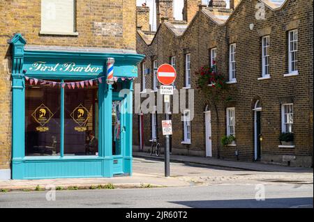 LONDRA - 20 maggio 2022: Barbiere e cartello stradale No Entry all'angolo di una strada. Vecchie case con terrazza in mattoni sullo sfondo Foto Stock