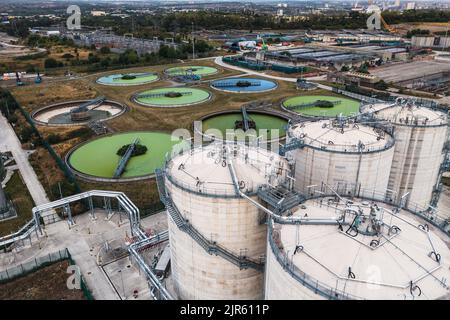Una vista aerea direttamente sopra un trattamento delle acque reflue funziona con serbatoi di stoccaggio circolari che filtrano le acque reflue con alghe verdi per l'acqua potabile Foto Stock