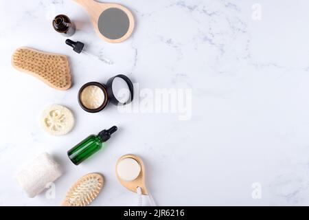 Vasetto crema idratante aperto ed essenziale o lozione in bottiglia di vetro ambrato e set di prodotti per la cura della pelle e del corpo su sfondo bianco. Confezioni cosmetiche Foto Stock