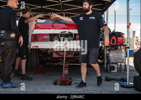 La BMW E30 ai box, i meccanici hanno sollevato la vettura con il martinetto per cambiare i cuscinetti e gli assali Foto Stock