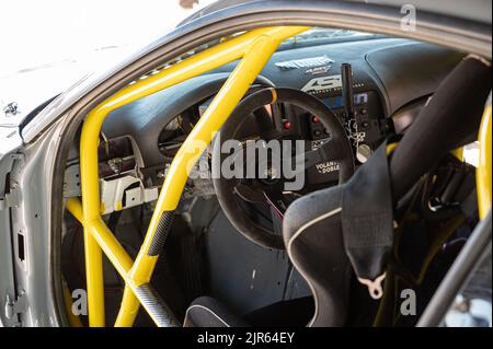 I dettagli del cockpit di un'auto da corsa drift, volante disassato, barre antirollio e freno a mano idraulico Foto Stock