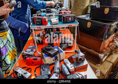 Un gruppo di vecchie telecamere d'epoca esposte su un tavolo rosso in un mercato delle pulci a Parigi, Francia Foto Stock