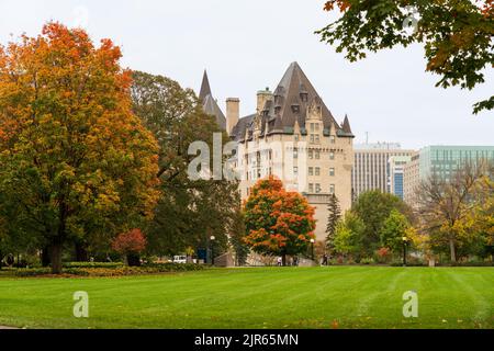 Ottawa, Ontario, Canada - 16 2021 ottobre: Paesaggio autunnale con foglie rosse di Major's Hill Park. Fairmont Chateau Laurier sullo sfondo. Foto Stock