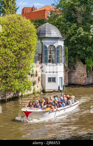 I turisti che si godono una gita guidata in barca intorno ai canali di Bruges, Belgio Foto Stock