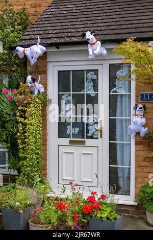 Flamstead Scarecrow Festival 2022 - Cruella de Vil e 101 Dalmatations Scarecrow e cani dalmati lamina decorare l'esterno di una casa, Flamstead. Foto Stock