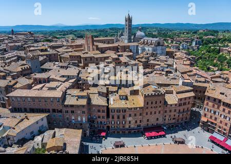 Vista dalla cima del campanile di Torr del Mangia che si affaccia su Piazza del campo e sui tetti di tegole rosse oltre il Duomo di Siena, Toscana, Italia Foto Stock