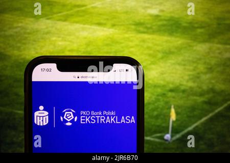 KONSKIE, POLONIA - 21 agosto 2022: Smartphone che mostra il logo della lega di calcio polacca PKO Bank Polski Ekstraklasa sullo sfondo dello stadio di calcio Foto Stock