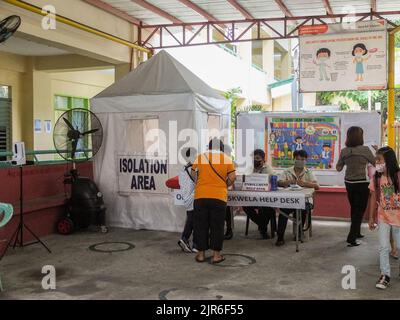 Malabon City, Filippine. 22nd ago, 2022. Una madre ed il suo figlio ottengono una richiesta al servizio di aiuto di iscrizione della scuola elementare di Tinajeros nella città di Malabon. Dopo due anni scolastici senza classi faccia a faccia, i corridoi vuoti e le aule saranno nuovamente riempiti di studenti, poiché il Dipartimento dell'Educazione (DepEd) apre formalmente l'inizio dell'anno scolastico 2022-2023 di lunedì 22 agosto. Credit: SOPA Images Limited/Alamy Live News Foto Stock