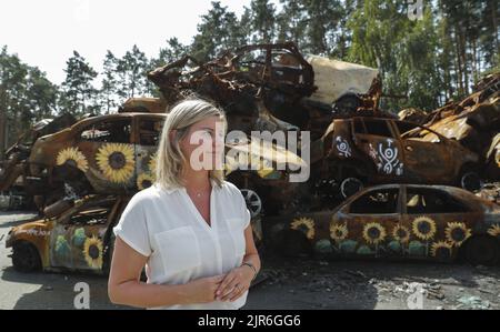 2022-08-22 12:00:07 il ministro olandese del Commercio estero e dello sviluppo Liesje Schreinemacher partecipa alla sua visita al cimitero delle auto civili danneggiate nella città di Irpin vicino a Kyiv, Ucraina, il 22 agosto 2022. I ministri olandesi del Commercio estero e dello sviluppo Liesje Schreinemacher e il ministro della Difesa Kajsa Ollongren visitano Kyiv e le città suraund per incontrare i funzionari ucraini. Irpin così come altre città e villaggi nella parte settentrionale della regione di Kyiv divenne campi di battaglia e furono pesantemente sgusciati quando le truppe russe tentarono di raggiungere la capitale Ucraina Kyiv nel febbraio e marzo 2022. ne Foto Stock