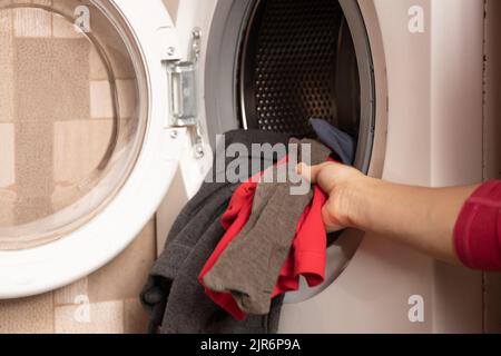 cose in lavatrice, lavatrice con le cose a casa in cucina, lavaggi, lavori di casa Foto Stock