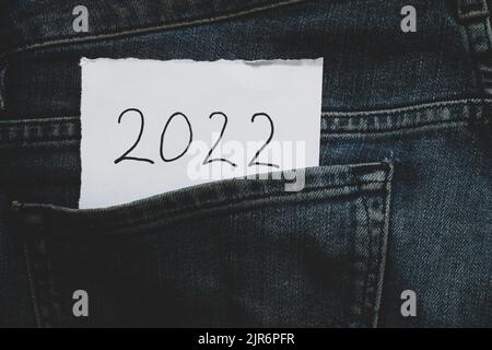 2022 scritto su carta che si trova in tasca di jeans, felice anno nuovo 2022, vacanza e moda Foto Stock