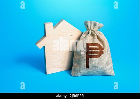 Silhouette della casa e una borsa di soldi del peso filippino. Acquisto casa, investimenti nella costruzione di immobili. Servizi di realtor. Sviluppo del progetto della casa. Foto Stock