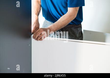 Fissaggio di legno compensato ad una cassa, parete posteriore di una cassa, installazione di un armadio scorrevole. Foto Stock