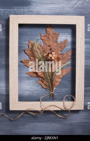 bouquet di foglia pressata essiccata su fondo blu. hobby, fatto a mano, arte floreale e stile boho. Foto Stock