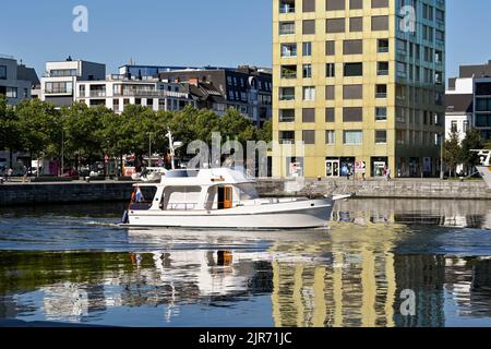 Anversa, Belgio - Agosto 2022: Piccola barca a motore che naviga in acqua ferma nel porto della città alla luce della mattina presto Foto Stock