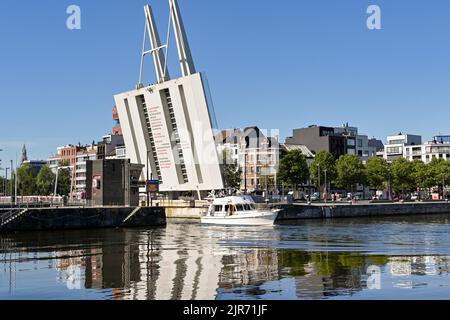 Anversa, Belgio - Agosto 2022: Piccola barca a vela pas un ponte di sollevamento nel porto della città alla luce del mattino presto Foto Stock