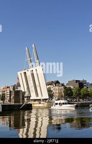 Anversa, Belgio - Agosto 2022: Piccola barca a vela pas un ponte di sollevamento nel porto della città alla luce del mattino presto Foto Stock