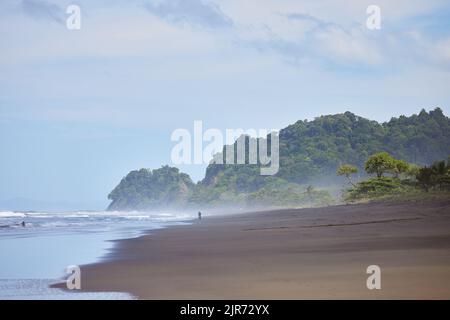 Una bella spiaggia di Playa Hermosa in Costa Rica con alberi lussureggianti sullo sfondo Foto Stock