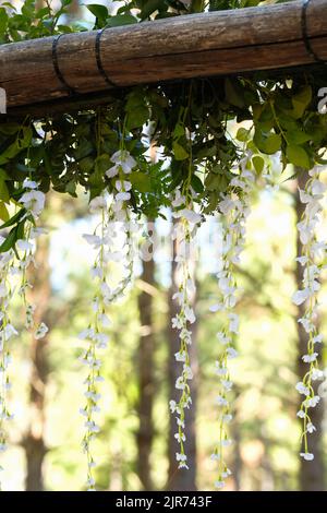 Un primo piano verticale di fiori bianchi di glicine appesi all'aperto Foto Stock