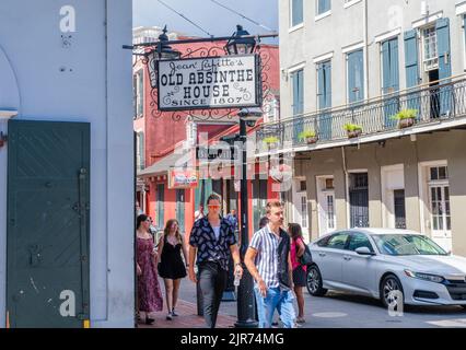 NEW ORLEANS, LA, USA - 20 AGOSTO 2022: I giovani turisti camminano vicino alla vecchia casa dell'Assenzio di Jean Lafitte all'angolo tra Bienville Street e Bourbon Street Foto Stock