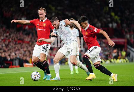 James Milner (al centro) di Liverpool combatte con Christian Eriksen (a sinistra) del Manchester United e Lisandro Martinez durante la partita della Premier League a Old Trafford, Manchester. Data immagine: Lunedì 22 agosto 2022. Foto Stock