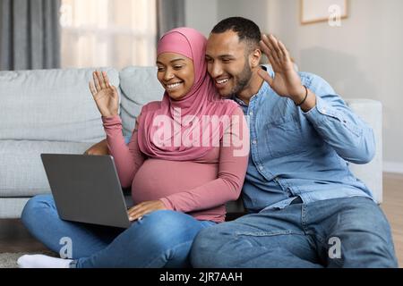 I coniugi musulmani neri si aspettano che il bambino effettui una videochiamata con il laptop a casa Foto Stock