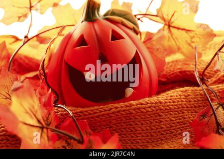 Composizione autunnale. Maglione in maglia di zucca e foglie d'autunno Foto Stock