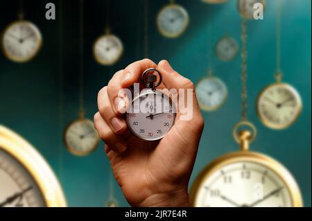 Una mano che aggrappa un cronometro mentre il tempo passa attraverso gli orologi volanti. Concetto di tempo che vola Foto Stock