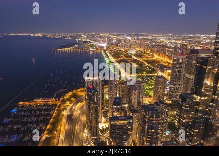 Un'immagine aerea dello skyline con luci contro un cielo blu al tramonto Foto Stock