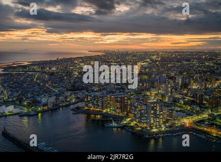 Bellissimo tramonto sulla città costiera e luci di prima serata Foto Stock
