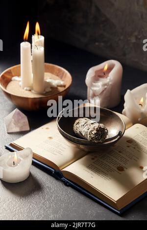 libro magico, salvia, candele bruciate e personale rituale Foto Stock